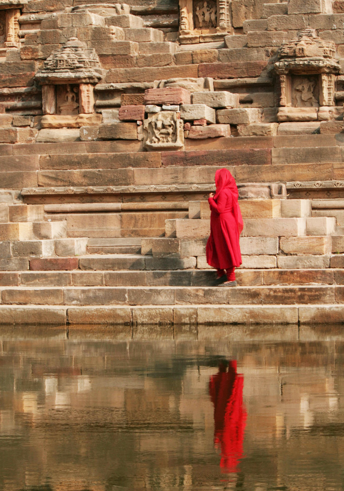 Visitor in Red Ascending Ancient Indian Temple Steps