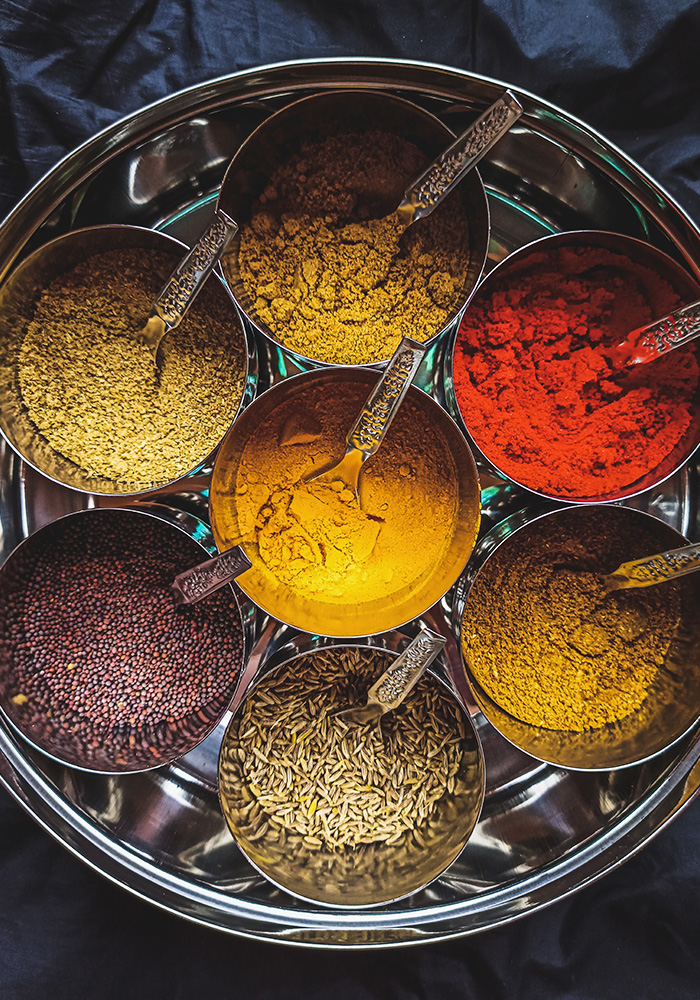 Aromatic spice collection displayed in a traditional Indian spice tray.