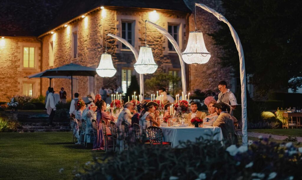 Guests in 17th-century attire enjoying the grand dinner at the Dominique Crenn Experience (fairytale setting).