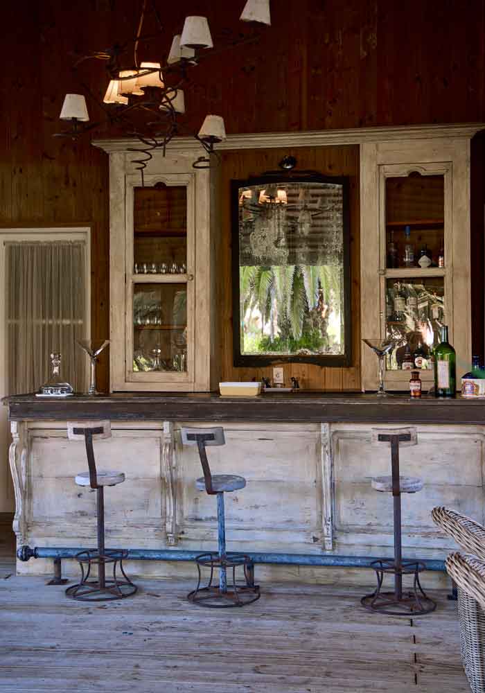 Bar with wooden stools and mirror at Casa Anna, Satopia Travel Uruguay experience.